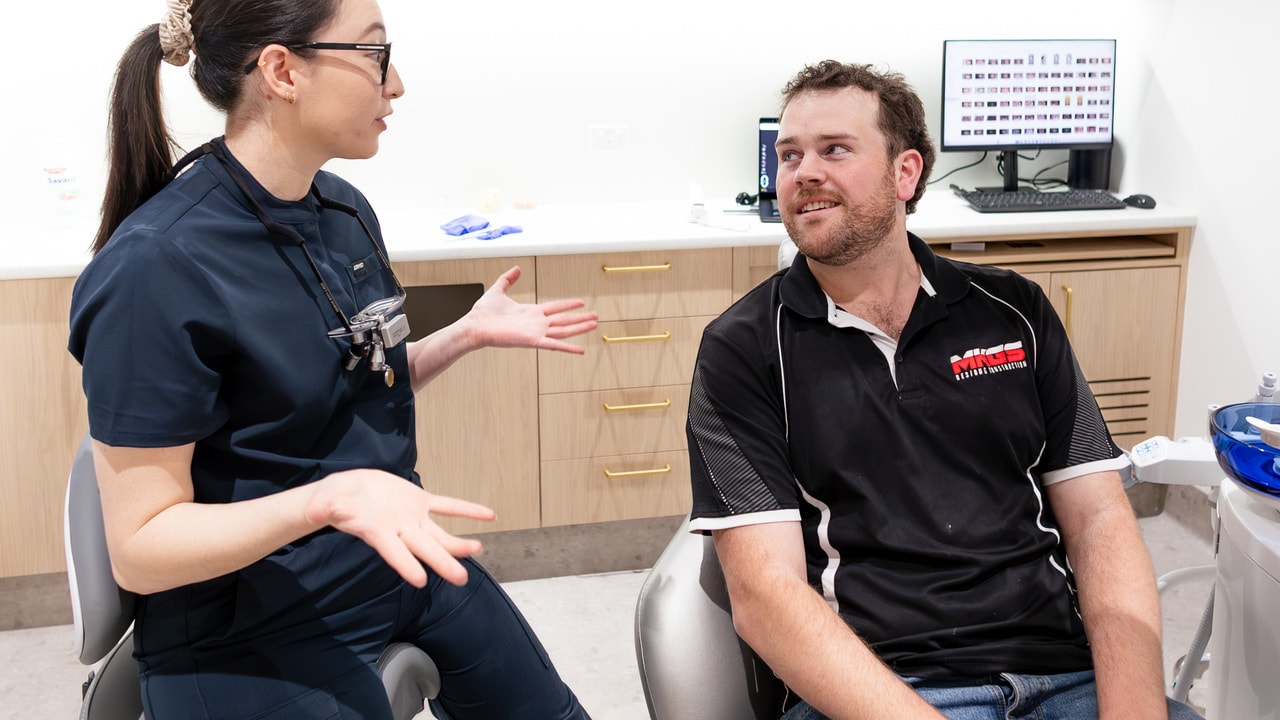 Dentist reviewing a professional whitening shade guide with a patient