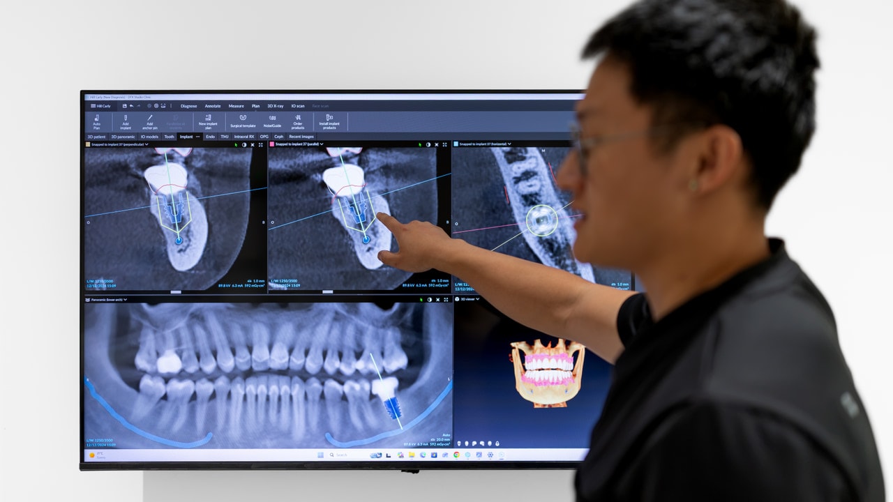 Dentist and patient reviewing a tooth extraction plan on a tablet